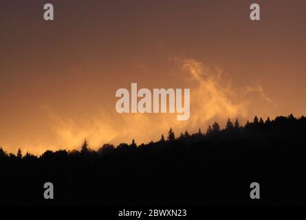 Couleurs et nuages orange au coucher du soleil dans le parc naturel des montagnes Apuseni, Roumanie Banque D'Images