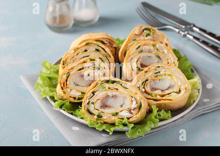 Rouleau de pita avec hareng, pommes de terre et oignons sur fond bleu clair, orientation horizontale, gros plan Banque D'Images