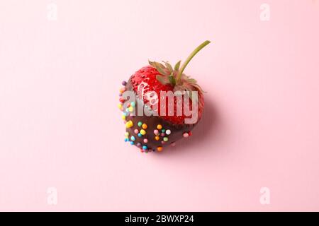 Fondue au chocolat. Fraise au chocolat sur fond rose Banque D'Images