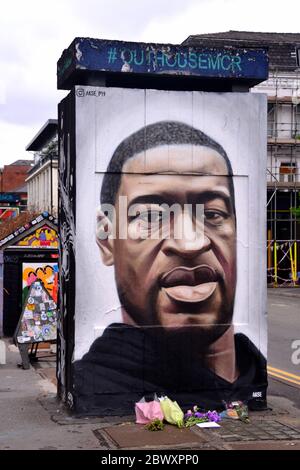 Des fleurs ont été laissées à une fresque représentant George Floyd, peinte par l'artiste de rue Akse, qui a récemment paru sur Stevenson Square, dans le centre de Manchester, en Angleterre, au Royaume-Uni. Floyd, un homme afro-américain, est décédé à Minneapolis, Minnesota, États-Unis, le 25 mai 2020, alors qu'il était arrêté par 4 policiers après qu'un assistant de magasin ait prétendu avoir essayé de payer avec une fausse facture de 20 $. Banque D'Images