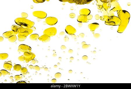 Gouttes d'huile d'olive. Résumé image des Blobs de l'huile d'or flottant dans l'eau. Bulles de gros plan isolées sur blanc Banque D'Images