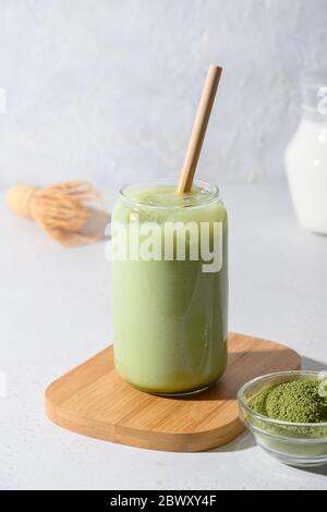 Thé vert glacé au matcha latte en verre sur fond blanc. Gros plan. Format vertical. Banque D'Images