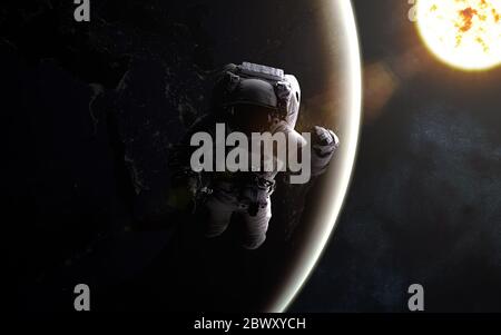 Astronaute dans l'espace. Soleil et terre Banque D'Images