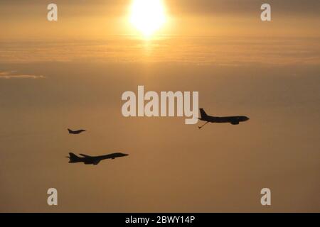 Un bombardier furtif de la 28e Escadre Bomb de la U.S. Air Force B-1B lancer est escorté par les combattants FGR4s de la RAF britannique, silhouetés par le soleil couchant le 20 mai 2020 au-dessus du Royaume-Uni. Banque D'Images