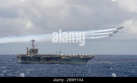 L'escadron de démonstration de vol, les Blue Angels, survole le porte-avions de la classe Nimitz USS Harry S. Truman en cours le 20 mai 2020 dans l'océan Atlantique. Le groupe de grève des transporteurs Harry S. Truman reste en mer dans l'Atlantique afin de protéger l'équipage des risques posés par la COVID-19. Banque D'Images