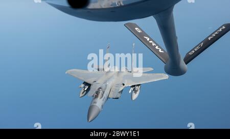 Un avion de chasse F-15 Eagle de la U.S. Air Force, affecté à la Garde nationale aérienne de Jacksonville, s'approche d'un KC-135 Stratotanker pour se ravitailler, tout en fournissant un appui aérien pour sécuriser la zone de lancement au-dessus du Kennedy Space Center le 29 mai 2020 près de Cape Canaveral, en Floride. Banque D'Images