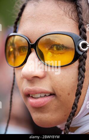 Portrait rapproché d'une jeune femme, avec des cheveux tressés, portant des lunettes de soleil, pendant la marche de protestation britannique Black Lives Matter. Hyde Park, Londres, Royaume-Uni Banque D'Images