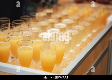 Des rangées de verres avec différentes boissons colorées sur une table de buffet. Célébration, anniversaire, fête, mariage. Banque D'Images