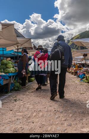 Photo de l'arrière d'un homme et d'une femme péruviens sur le marché local dans le village de Pisac du Pérou. Banque D'Images