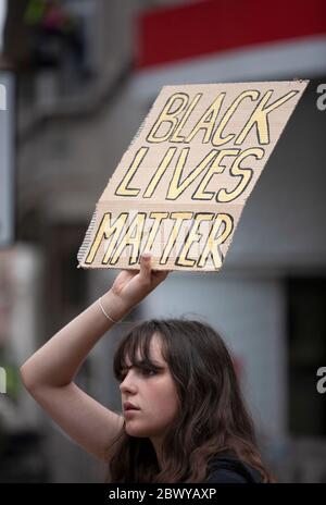 Jeune femme tenant un panneau 'Black Lives Mater' au-dessus de son signe de tête pendant la marche de protestation de BLM. Londres, Angleterre, Royaume-Uni Banque D'Images