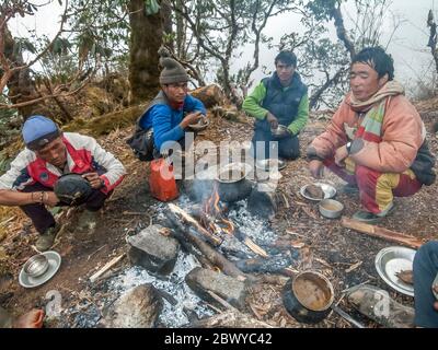 Népal. Partez à Mera Peak. Un groupe de porteurs népalais a mis sur pied un camp de make-shift pour prendre le petit déjeuner sur le sentier de randonnée près de la colonie de Khote Banque D'Images