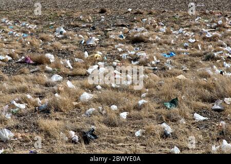 Sacs en plastique jetés dispersés le long de la voie publique. Banque D'Images