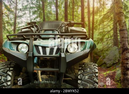 Photo d'un véhicule vtt de chasse à l'offroade vert debout en forêt, vue de face. Banque D'Images