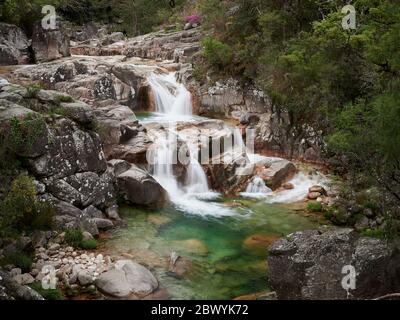 Cascade de Mata de Albergaria au milieu des bois, l'eau coule sur les rochers jusqu'au lac de Green Banque D'Images