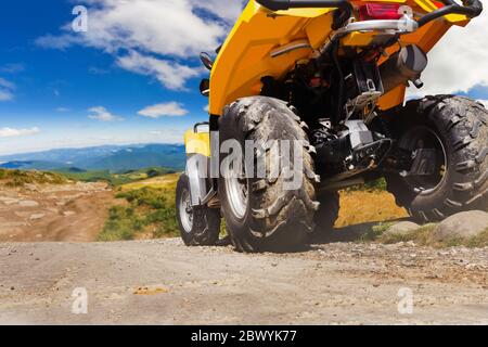 Photo d'un véhicule vtt de tourisme jaune sur une route de montagne vue rapprochée arrière. Banque D'Images