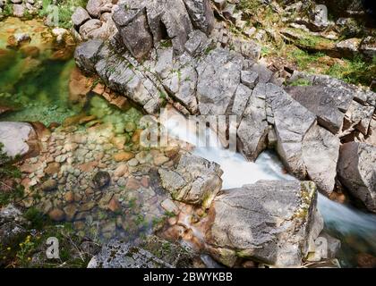 Cascade de Mata de Albergaria au milieu des bois, l'eau coule sur les rochers jusqu'au lac de Green Banque D'Images