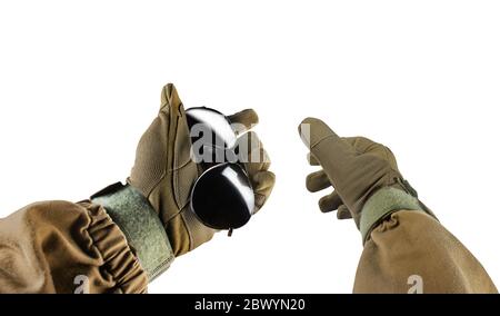 Photo isolée d'une première personne qui a vu les bras dans une veste tactique et des gants tenant des lunettes de soleil noires sur fond blanc. Banque D'Images