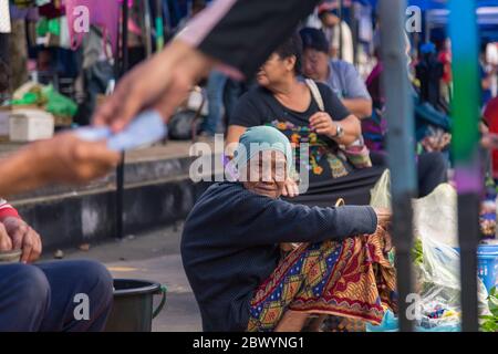 Tuaran, Sabah, Malaisie-janvier 21,2018: Jeune femme musulmane malaisienne locale qui vend des boissons au marché hebdomadaire de Tuaran, Sabah, Malaisie Banque D'Images