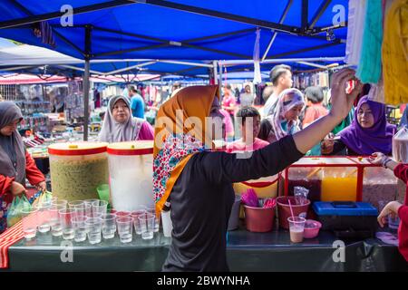 Tuaran, Sabah, Malaisie-janvier 21,2018: Jeune femme musulmane malaisienne locale qui vend des boissons au marché hebdomadaire de Tuaran, Sabah, Malaisie Banque D'Images