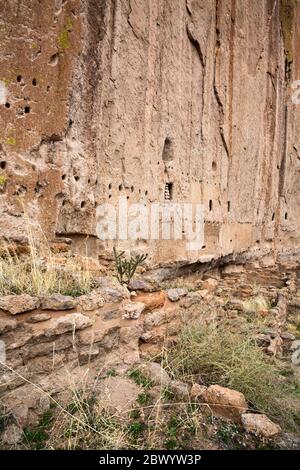 NM00466-00...NOUVEAU MEXIQUE - fondations anciennes à la base d'une falaise qui trou percé dans la pierre pour soutenir les toits et les planchers de la longue Maison i. Banque D'Images