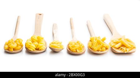 Divers types de pâtes italiennes crues en cuillères en bois isolées sur fond blanc. Banque D'Images