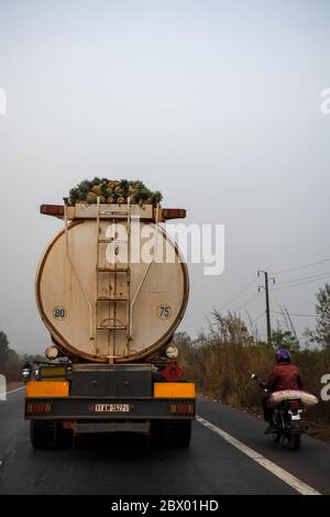 Afrique, Afrique de l'Ouest, Togo, kara. Chargement d'annas sur un camion à essence roulant sur une route togolaise. Banque D'Images