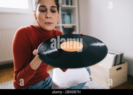 Jeune femme soufflant de la poussière de vinyle record Banque D'Images