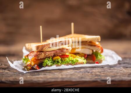 Sandwich club sur une table rustique poulet sorcière, bacon et légumes Banque D'Images