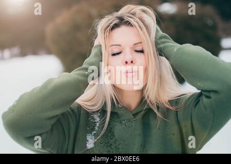 Aspect scandinave blond naturel - la sueur dans la rue en hiver fait un baiser Banque D'Images