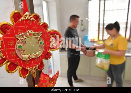 (200604) -- XIUSHUI, 4 juin 2020 (Xinhua) -- le villageois réétabli Hu Shanghai et son épouse préparent un déjeuner dans leur nouvelle maison dans une communauté de réinstallation de lutte contre la pauvreté dans le canton de Shangfeng, dans le comté de Xiushui, province de Jiangxi, en Chine orientale, le 21 mai 2020. La famille a déménagé ici en 2017. Au cours de la période du 13ème Plan quinquennal (2016-2020) de la Chine, le gouvernement local de Xiushui a construit 141 communautés de réinstallation pour plus de 10,000 000 habitants ruraux pauvres, qui avaient l'habitude de lutter contre la vie dans les régions montagneuses du comté. Les résidents ruraux réinstallés ont maintenant accès à de meilleurs hôpitaux, sc Banque D'Images