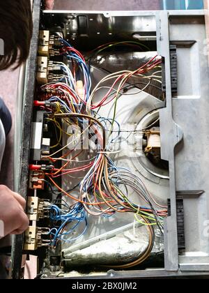 le réparateur démonte le poêle électrique pendant la réparation dans la cuisine maison Banque D'Images