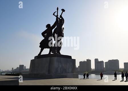 Pyongyang, Corée du Nord - 1er mai 2019 : statue de Juche composée de trois figures idéalisées chacune tenant un outil – un marteau (ouvrier), une faucille (paysan), Banque D'Images