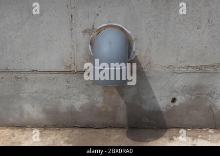 tuyaux d'évacuation en plastique installés dans des murs en béton. Banque D'Images