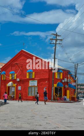 Bridgetown, Barbade, Caraïbes - 22 sept 2018: Belle maison rouge colorée avec des volets jaunes. Ciel bleu avec nuages blancs. Copier l'espace. Verticale Banque D'Images