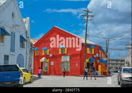 Bridgetown, Barbade, Caraïbes - 22 sept 2018: Belle maison rouge colorée avec des volets jaunes. Nuages blancs dans le ciel bleu. Copier l'espace Banque D'Images