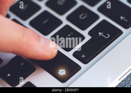 Gros plan du doigt de l'homme touchant le bouton de la touche Maj de la lettre sur le clavier noir de l'ordinateur Banque D'Images