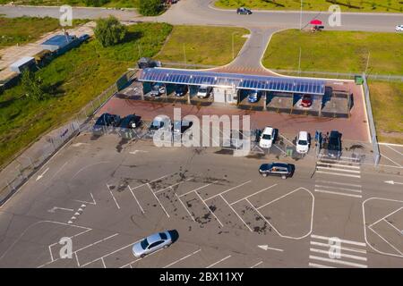 Photographie aérienne de lavage de voiture en libre-service les voitures sont sur les poteaux d'un lavage de voiture. Les gens lavent leur voiture. Banque D'Images