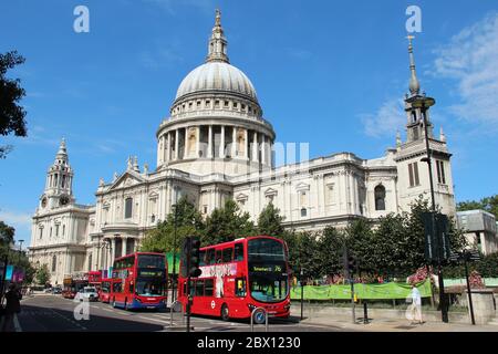 Des bus rouges à impériale passent devant la cathédrale Saint-Paul sous le soleil d'été à Londres, au Royaume-Uni. Banque D'Images