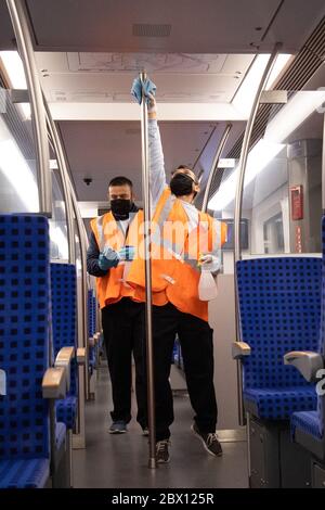 04 juin 2020, Hambourg: Des membres d'une équipe d'hygiène de DB-Service pour le S-Bahn de Hambourg travaillent dans un train S-Bahn lors d'un voyage dans le tournant à la gare d'Altona. Lors d'une manifestation médiatique jeudi, S-Bahn, VHH (Verkehrsbetriebe Hamburg-Holstein GmbH) et Hochbahn ont fourni des informations sur les équipes d'hygiène mobiles dans les bus, les trains et aux arrêts. Désormais, en plus du nettoyage quotidien de tous les véhicules et installations, ils réaliseront des mesures de nettoyage désinfectantes pendant les opérations en cours, comme mesure de précaution contre la pandémie de corona. Photo: Christian Charisius/dpa Banque D'Images