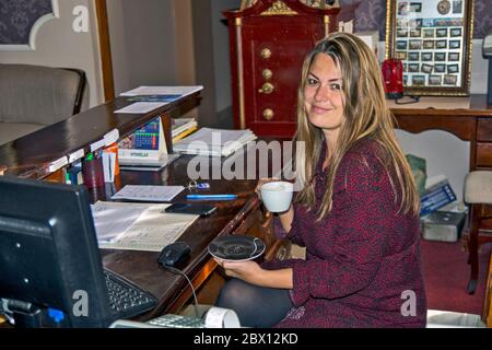 Becej, Château de Fantast, Serbie le 19 mai 2020. Une jeune réceptionniste dans un hôtel de château boit du café pendant une pause et un repos. Banque D'Images