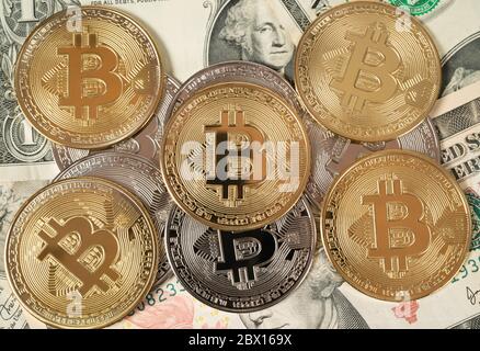 Bitcoins d'or et d'argent sur les billets en dollars américains, visualisant la crypto-monnaie Banque D'Images