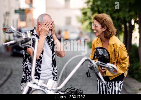 Un couple de personnes âgées gaies amoureux de la moto en ville. Banque D'Images