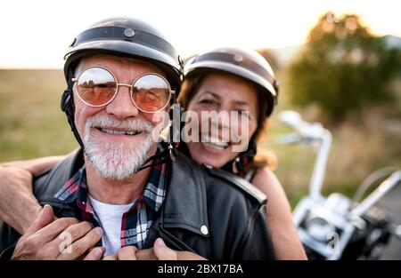 Un couple senior joyeux avec moto à la campagne. Banque D'Images