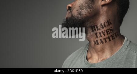 Gros plan noir homme fatigué de la discrimination raciale a tatoué slogan noir vies matière sur son cou. Notion de droits de l'homme, égalité, justice, problème de la violence et du racisme, discrimination. Circulaire. Banque D'Images