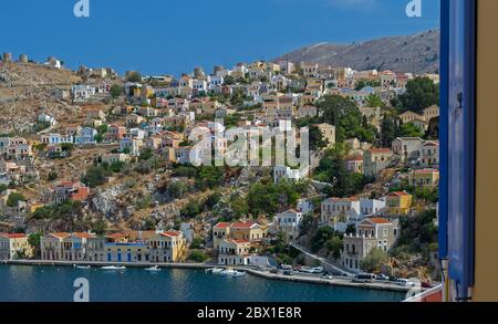 Vue sur le port depuis une fenêtre de l'étage supérieur à Simi, Grèce Banque D'Images