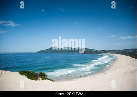 One Mile Beach, Forster, Nouvelle-Galles du Sud, Australie. Belle plage de sable s'étend loin au loin, entourée de dunes, de collines et de ciel bleu Banque D'Images