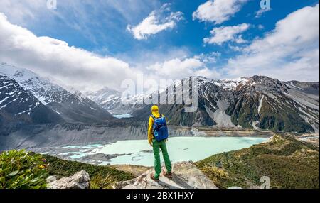 Le randonneur se dresse sur des rochers, avec vue sur la vallée de Hooker depuis le Sealy Tarns Track, les lacs glaciaires Mueller Lake et Hooker Lake, le parc national de Mount Cook Banque D'Images