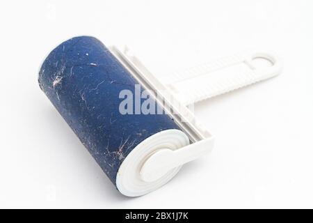 Brosse collante bleue pour nettoyer les vêtements et les meubles de la poussière sur fond blanc. Banque D'Images