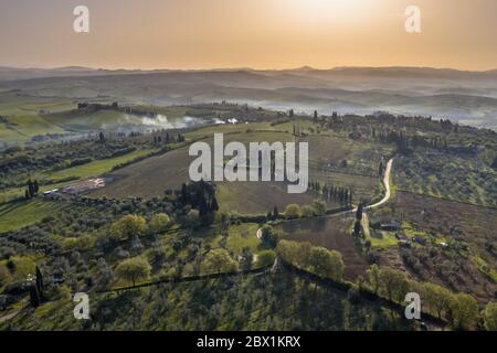 Vue aérienne sur la campagne toscane au lever du soleil matinal, en Toscane, en Italie, en avril. Banque D'Images