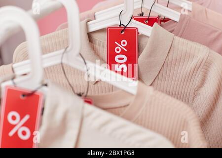 Gros plan des vêtements suspendus sur le porte-vêtements avec solde Banque D'Images